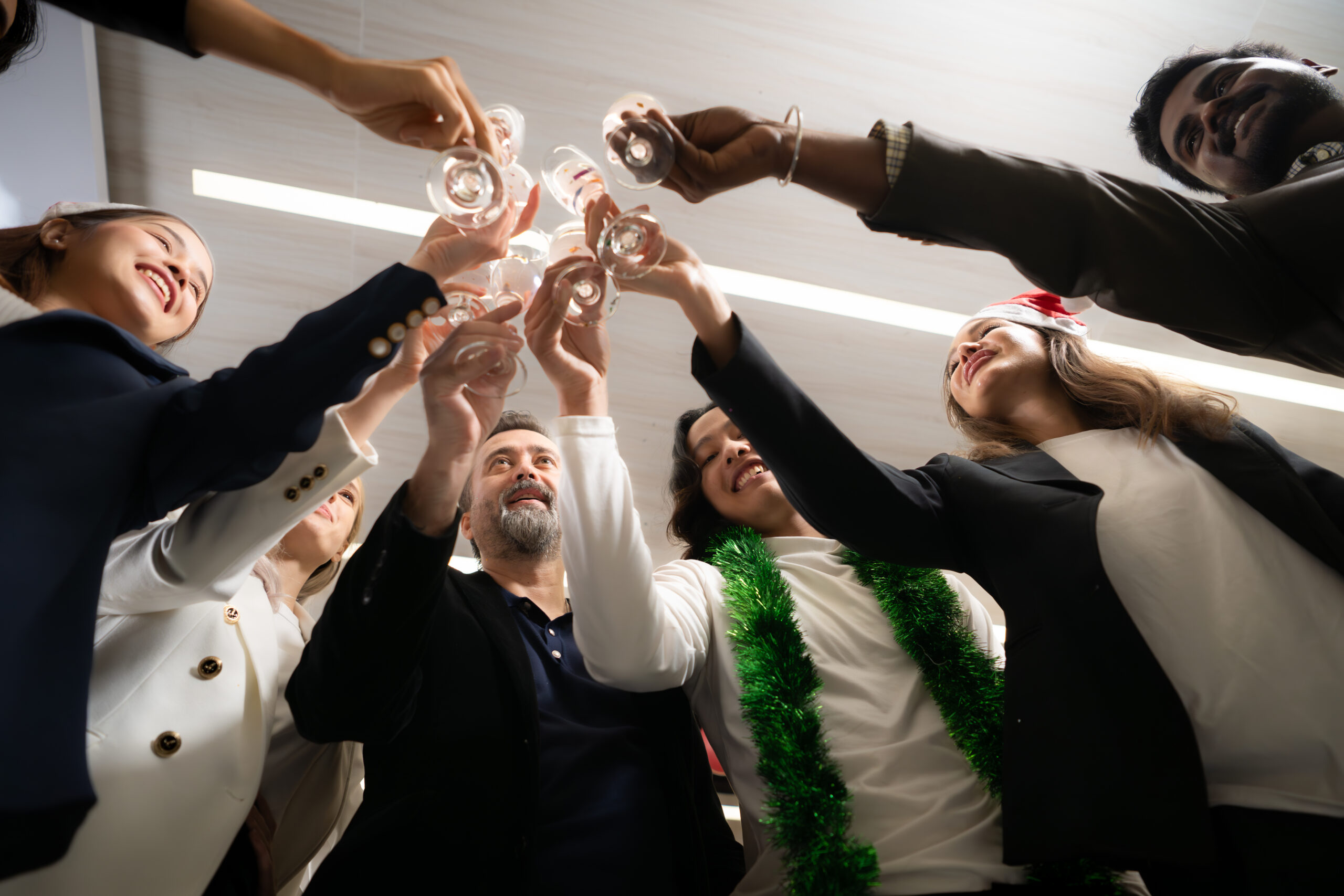 Group of friends toasting with champagne at New Year party in office